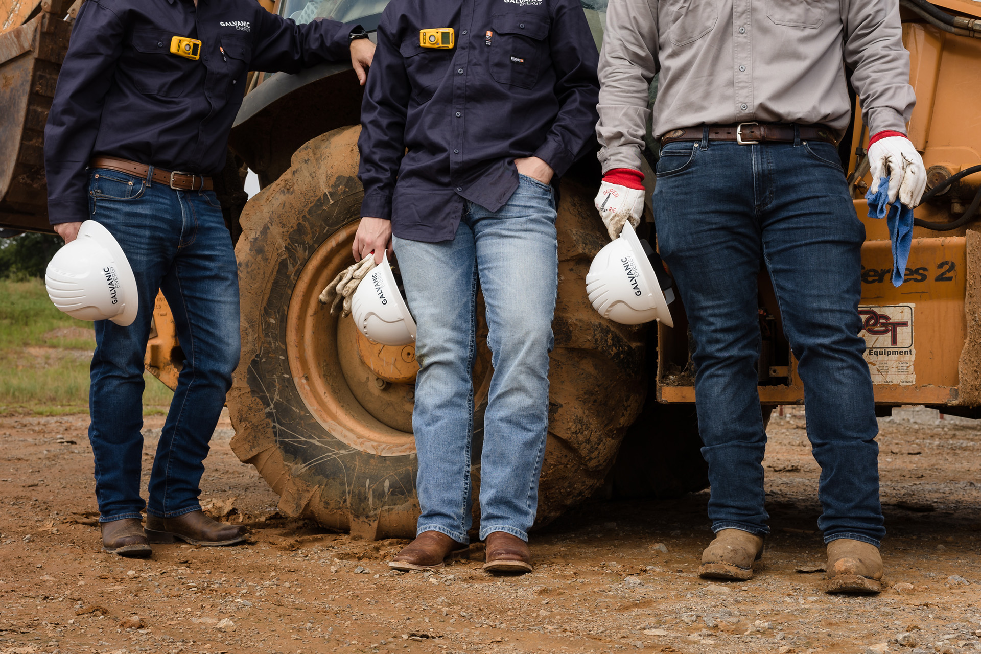 Decorative background image - Galvanic Energy employees holding branded hard hats